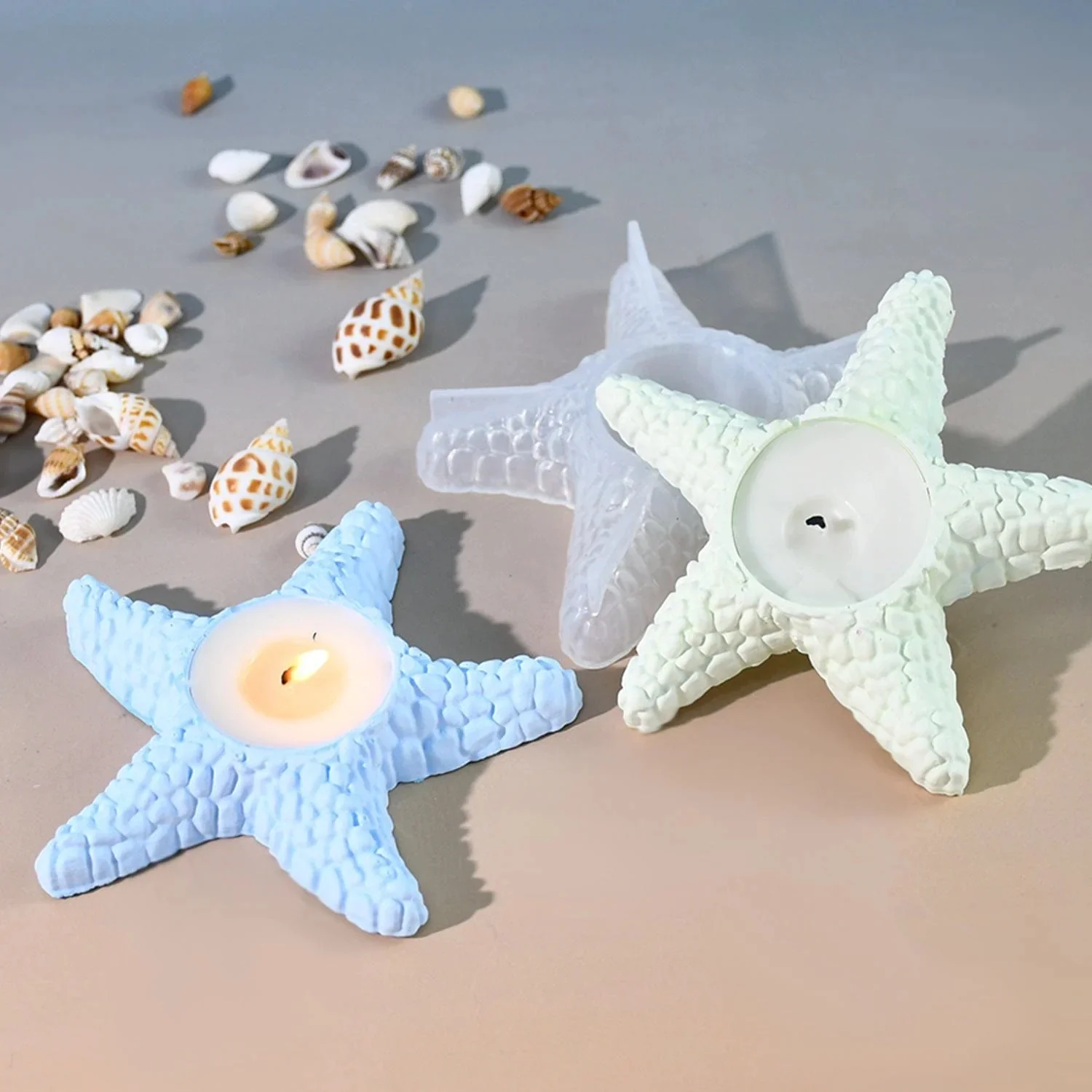 Handcrafted starfish candles on sand with seashells